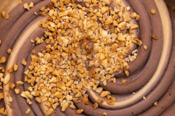 Chocolate ice-cream background  with chopped fresh nuts 
