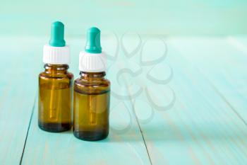 Small medical bottles on the blue wooden background