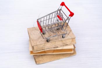 Shopping cart on books. Buying or selling books concept.