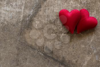 Two cute red hearts on the old grunge background. Copy space.