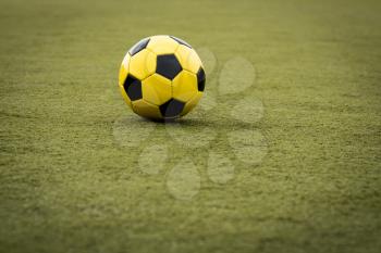 Yellow soccer ball on artificial turf soccer field
