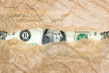 US currency macro peeking through torn brown paper