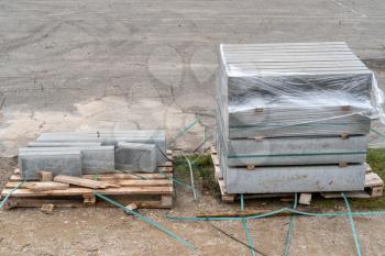 Gray stones on the wooden pallets standing on the ground outdoors. Concept of road repair