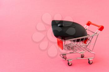  Buy and sell online. Computer mouse and  shopping cart with copy-space