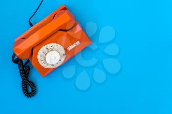  Orange telephone on blue background with copy space