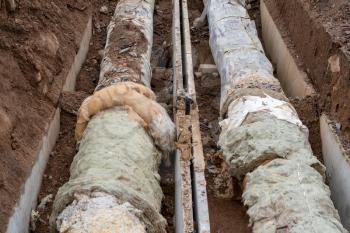 Old pipes in trench, repair of the heat route pipeline
