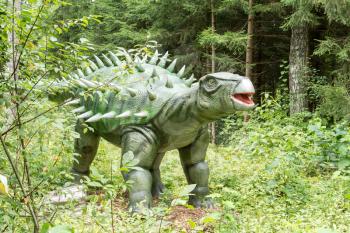 Statue of Talarurus dinosaur in a green forest
