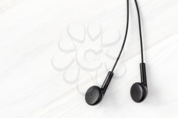 Earphones on wooden background with copy-space