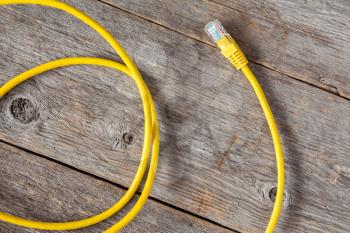 Yellow internet cable on the old wooden background