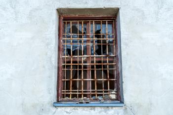 Rusted iron bars and broken glass window