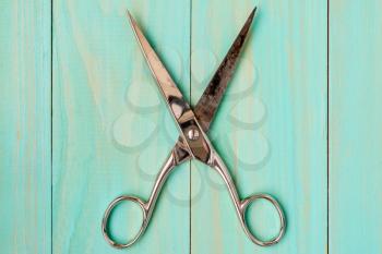 Old scissors for cutting fabric on wooden background