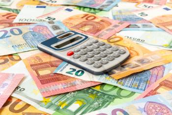 Euro currency with a digital calculator. Savings, finances and economy concept