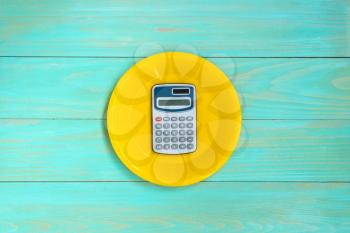 Empty plate with a calculator on it - food costs concept 