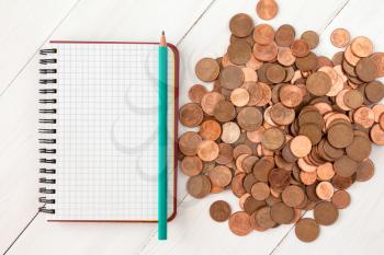 Blank notebook and pile of euro cent coins