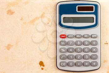 Electronic calculator on old brown paper background