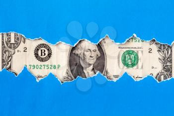 One dollar macro through torn blue paper