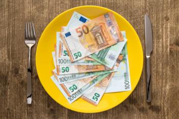High price of food concept: Eating money for dinner