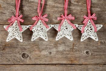 Four Christmas stars hanging on the wooden background
