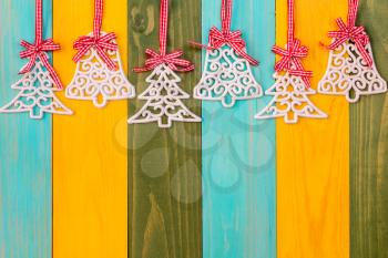 Christmas baubles and glittery xmas over colored wooden background