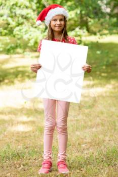 Child girl with Christmas hat holds blank advertisement banner