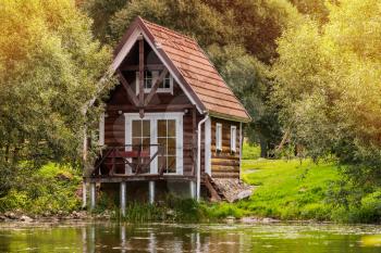 Small wooden house near the lake, sunny summer day