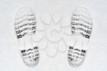 Feet imprint in fresh white snow, top view