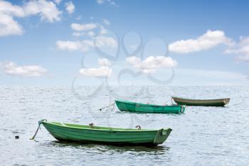 Three wooden boats floating out to sea