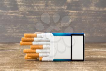 Pack of cigarettes lying on a wooden background