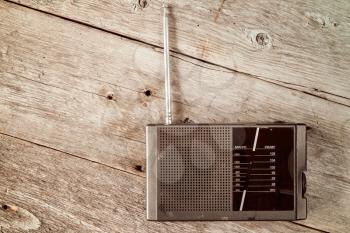 Old radio receiver device on the weathered wooden background