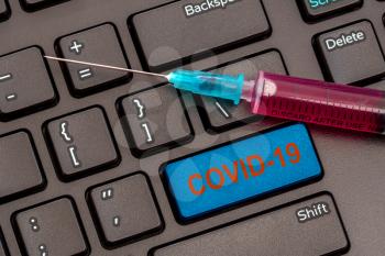 Vaccine and syringe injection on computer keyboard. It use for prevention,immunization and treatment from corona virus infection(novel coronavirus disease 2019,COVID-19).