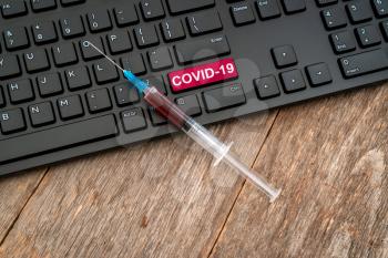 Syringe with vaccine on computer keyboard. It use for prevention,immunization and treatment from corona virus infection(novel coronavirus disease 2019,COVID-19).