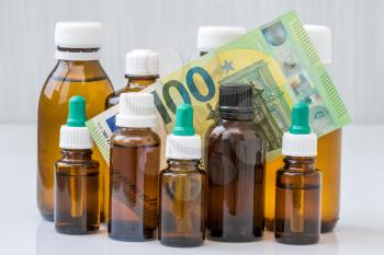 Expensive medication treatment. Money in the middle of glass bottles with medicine and money