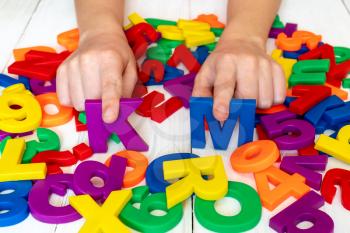 Child learning using magnetic numbers and letters. Education School Concept