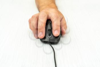 Man using a computer mouse on a white table. Front view.