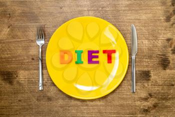 Word DIET made of colorful letters on a plate