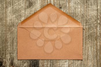 Open brown envelope lying on wooden background