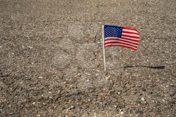 American flag in asphalt road crack