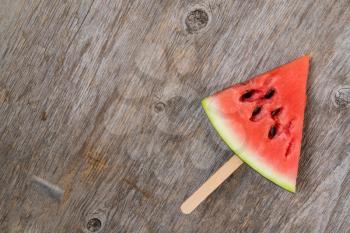 Watermelon slice popsicle on a old wood background. Copy space