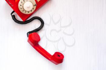  Vintage red telephone on wooden background, top view, pick up the phone
