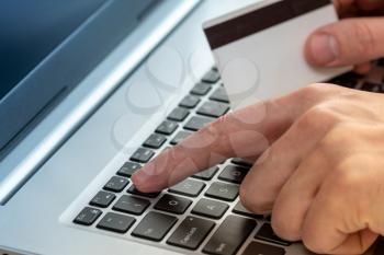 Hands holding credit card and using laptop. Online shopping concept.