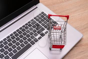 E-commerce. Shopping cart on laptop. Conceptual image.