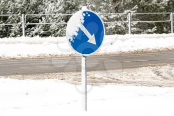 Warning traffic sign. Frozen Road ice-covered direction sign detour on the right. Snowy frozen roads in winter. 