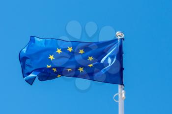 A flag of european union is waving on a background of clear sky 