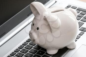 Piggy Bank on laptop keyboard. Make money online or internet business concepts