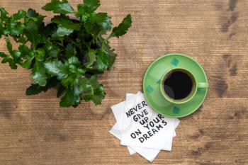  Never Give Up On Your Dreams - handwriting on a napkin with a cup of coffee and plant