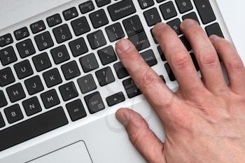 Top view of male hand using modern laptop