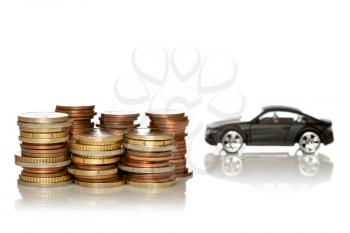 Saving for a new car. Coin stacks in front of car on white background