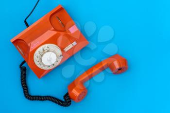  Communication support, call center and customer service help concept.  Orange telephone on blue background with copy space.