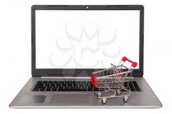 E-commerce. Shopping cart on laptop keyboard,isolated on white background