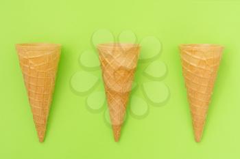 Three sweet wafer cones on green background